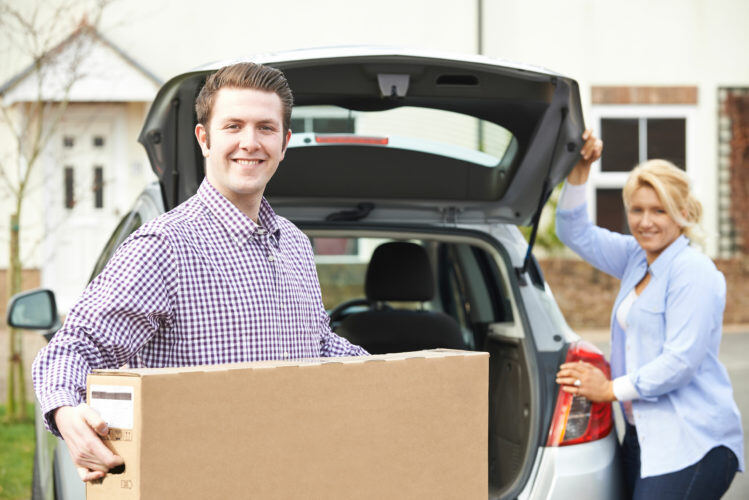 Couple Unloading New Television From Car Trunk